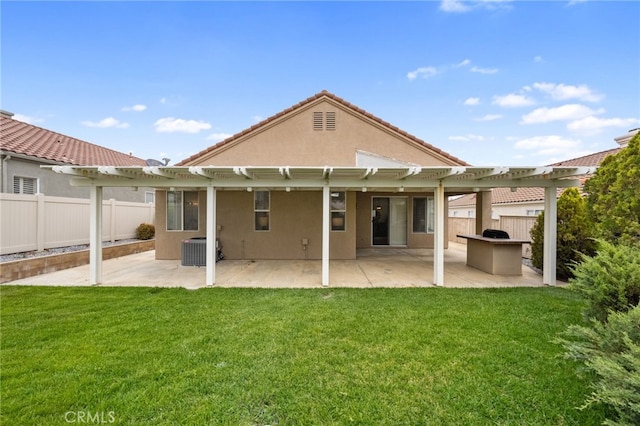 rear view of property featuring a lawn, fence, and a pergola