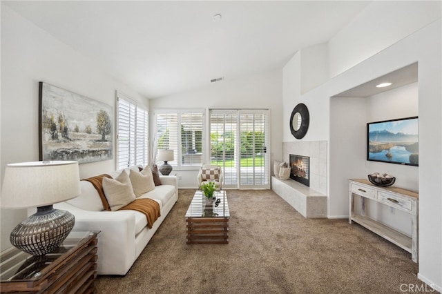 carpeted living room with baseboards, visible vents, lofted ceiling, and a fireplace