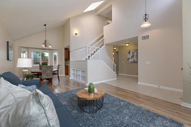 1684 Charlie Horse Way, Oceanside, CA 92057 - living area with stairway, wood finished floors, high vaulted ceiling, a chandelier, and a skylight