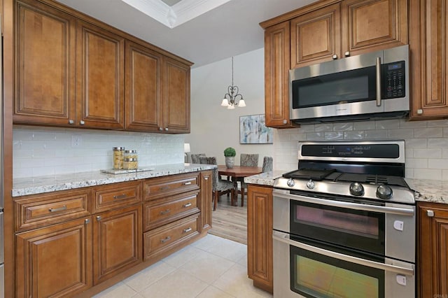 1684 Charlie Horse Way, Oceanside, CA 92057 - kitchen with appliances with stainless steel finishes, a chandelier, brown cabinets, and crown molding