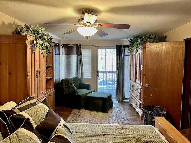 bedroom featuring access to outside, a ceiling fan, and wood finished floors