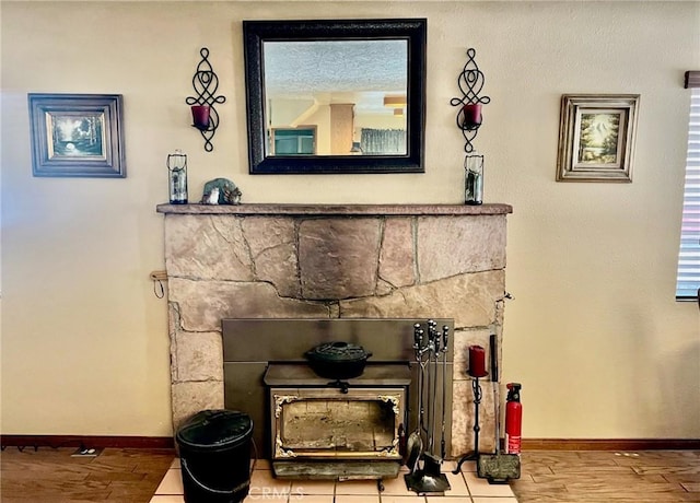 details with baseboards, a stone fireplace, wood finished floors, and a fire extinguisher