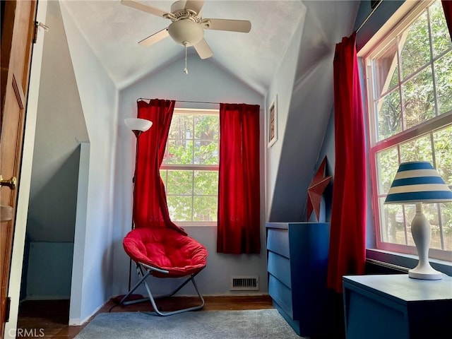 interior space with a ceiling fan, visible vents, wood finished floors, and lofted ceiling
