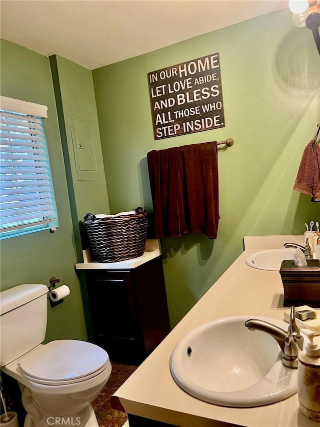 bathroom featuring a sink, toilet, and double vanity