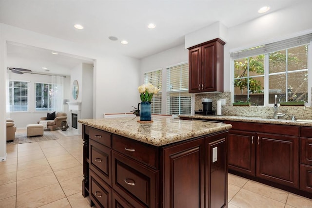kitchen with a center island, recessed lighting, a healthy amount of sunlight, light tile patterned floors, and backsplash