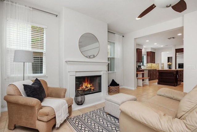 2258 Aventurine Pl, Carlsbad, CA 92009 - living area with light tile patterned floors, a ceiling fan, a glass covered fireplace, recessed lighting, and baseboards
