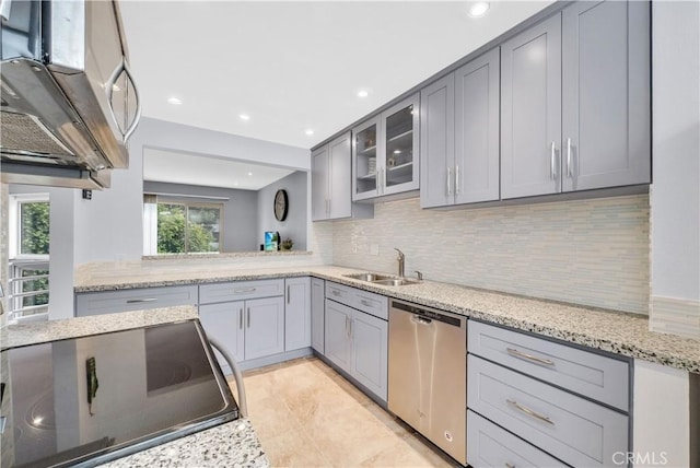 kitchen featuring a sink, decorative backsplash, dishwasher, and gray cabinetry