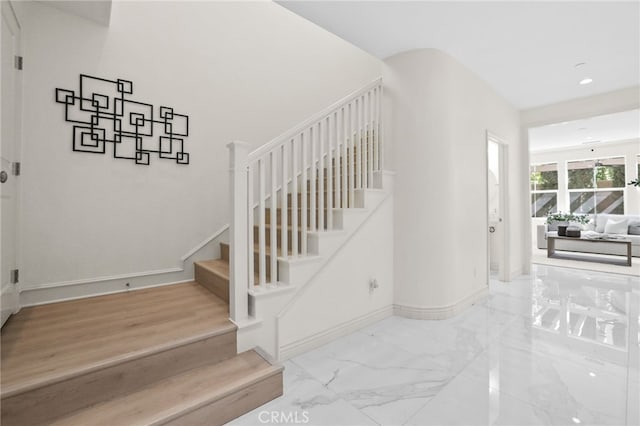 staircase with recessed lighting, baseboards, and marble finish floor