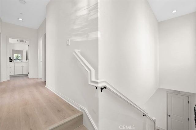 stairway featuring recessed lighting, baseboards, and wood finished floors