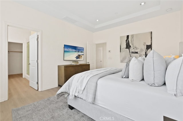 bedroom featuring a walk in closet, recessed lighting, baseboards, light wood-type flooring, and visible vents