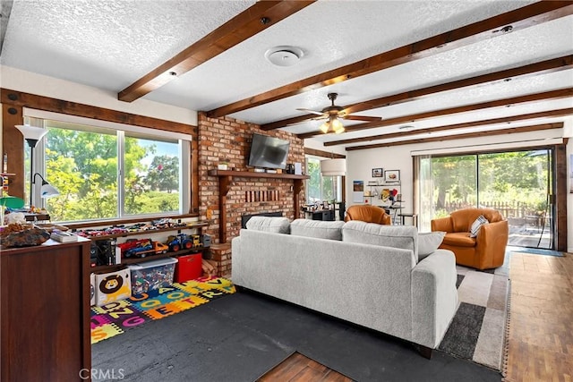 26231 Wilson St, Los Molinos, CA 96055 - living room with ceiling fan, a textured ceiling, a brick fireplace, beam ceiling, and wood finished floors