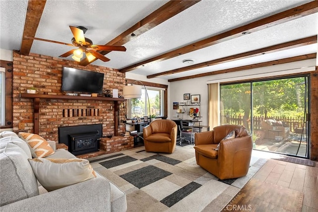 26231 Wilson St, Los Molinos, CA 96055 - living area with ceiling fan, a fireplace, a textured ceiling, wood finished floors, and beamed ceiling
