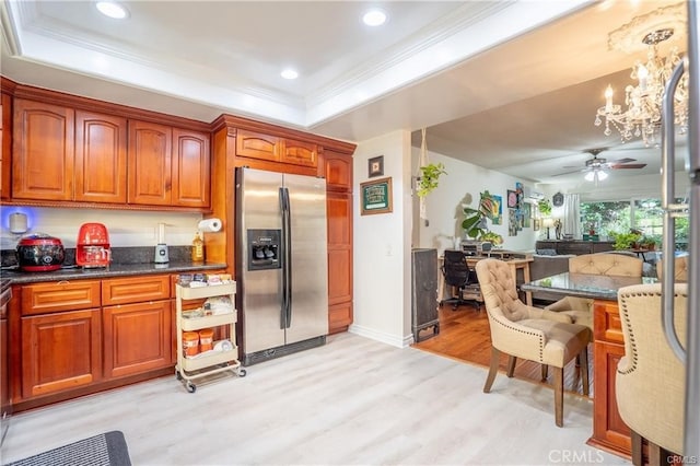 kitchen with crown molding, open floor plan, stainless steel refrigerator with ice dispenser, brown cabinets, and light wood-style flooring
