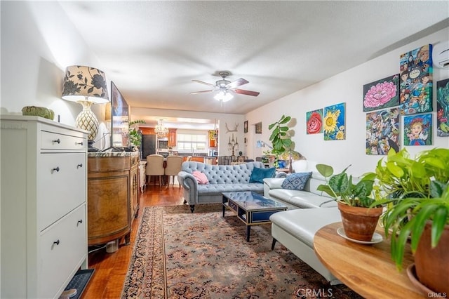 living room featuring a textured ceiling, ceiling fan, and wood finished floors