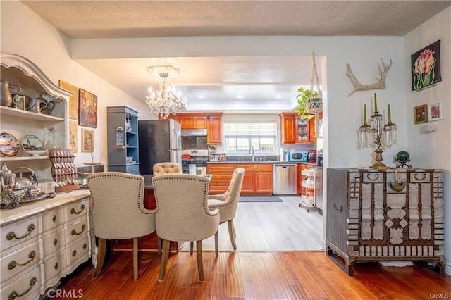 dining room featuring light wood-style floors, a tray ceiling, and a chandelier