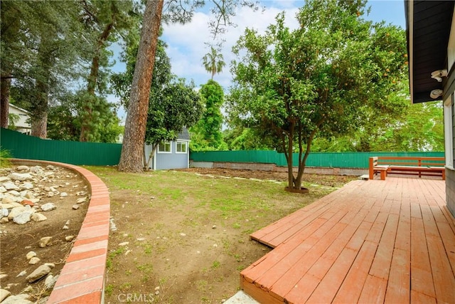 view of yard featuring a fenced backyard, an outdoor structure, and a wooden deck