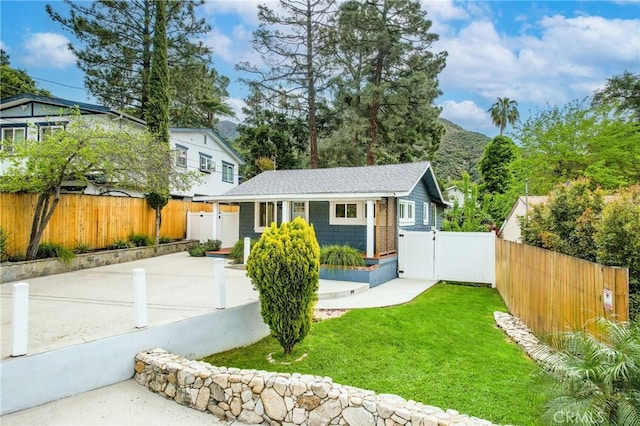 view of front of home featuring fence private yard and a front yard
