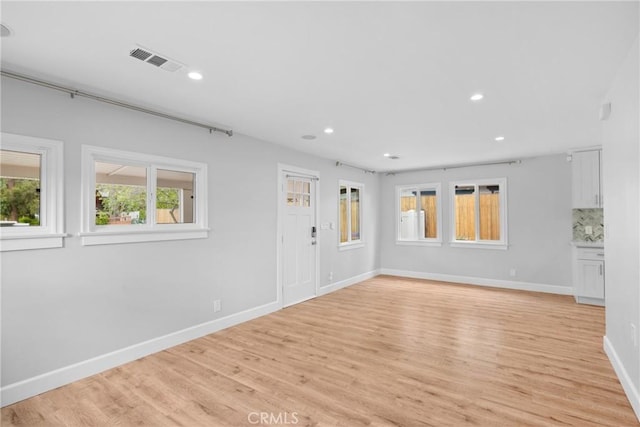 unfurnished room with light wood-style floors, baseboards, recessed lighting, and visible vents