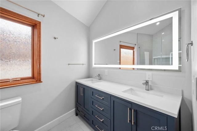 bathroom with a sink, toilet, marble finish floor, baseboards, and vaulted ceiling