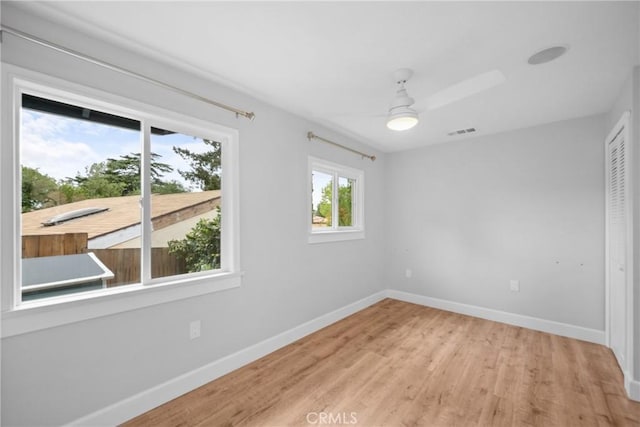 unfurnished room featuring a ceiling fan, baseboards, visible vents, and light wood-style flooring