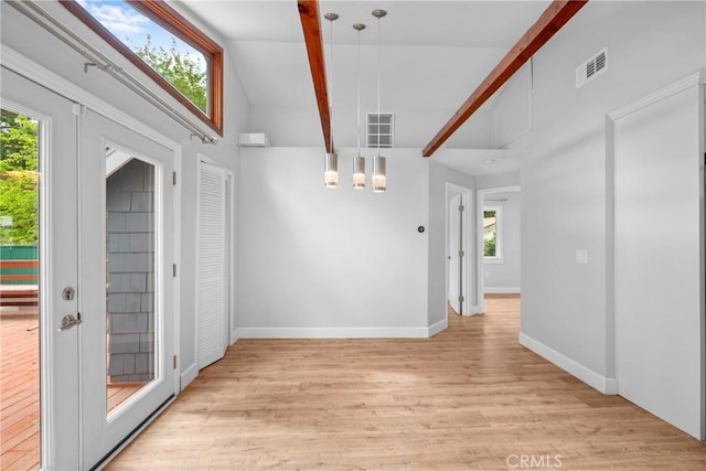 unfurnished dining area featuring an inviting chandelier, beamed ceiling, light wood-type flooring, and visible vents