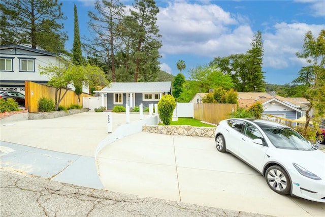 view of front of house with concrete driveway and fence private yard