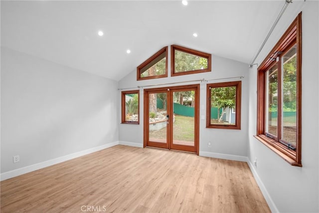 interior space featuring light wood-type flooring, recessed lighting, baseboards, and lofted ceiling