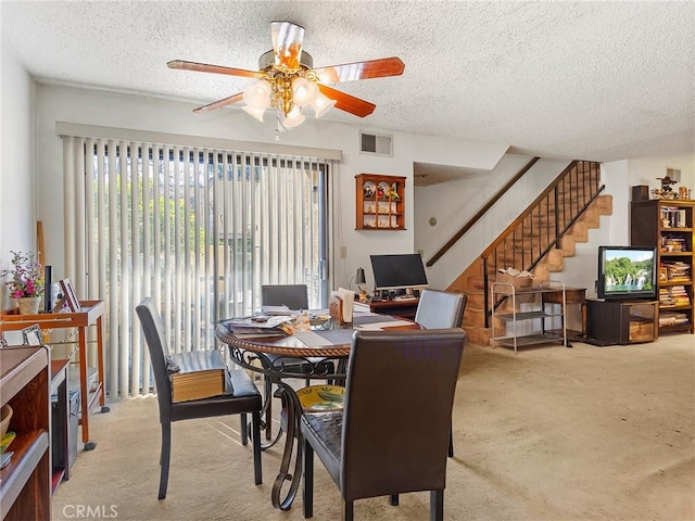 dining space with carpet flooring, a textured ceiling, and visible vents