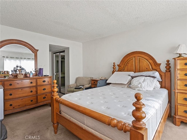 bedroom with light carpet and a textured ceiling