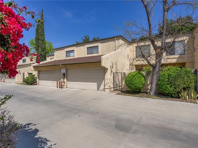 view of front of home featuring a garage, stucco siding, and driveway