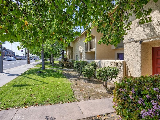 exterior space with stucco siding and a yard