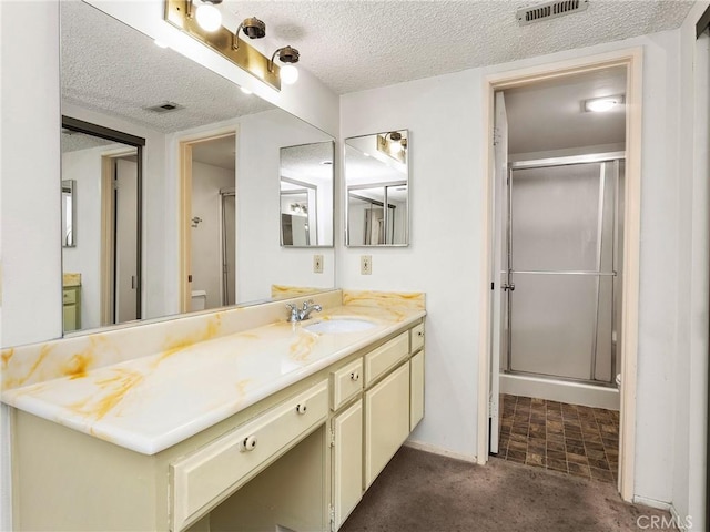 bathroom with visible vents, a textured ceiling, and a stall shower