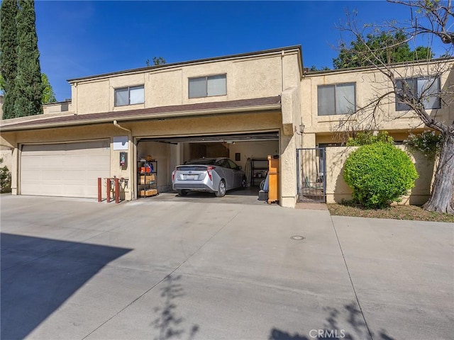 view of front facade featuring an attached garage, stucco siding, and concrete driveway