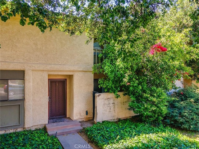 property entrance with stucco siding