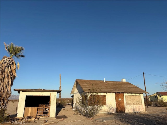 view of front of house with an outdoor structure and stucco siding