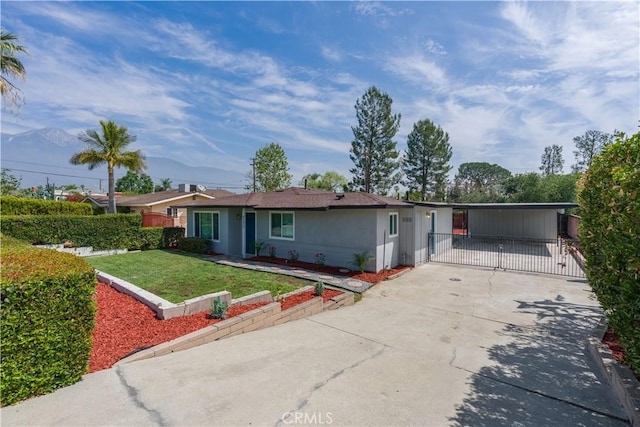 ranch-style house with a carport, concrete driveway, and a front yard