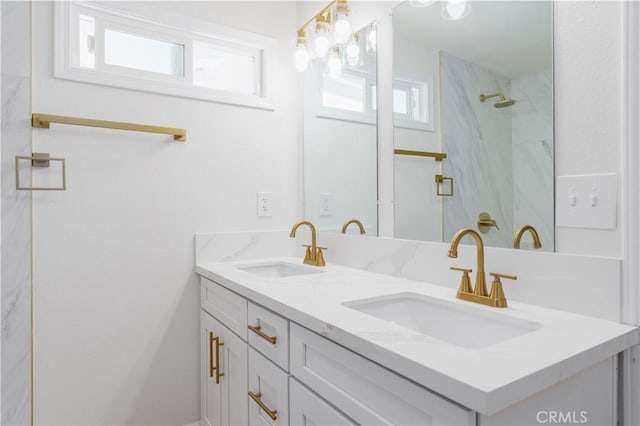 bathroom featuring double vanity, a sink, and walk in shower