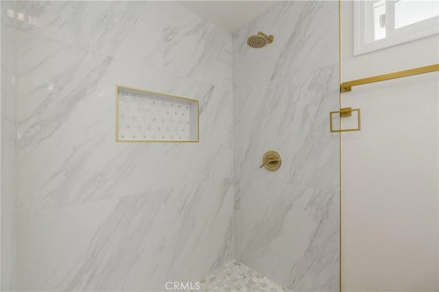 interior details featuring a marble finish shower