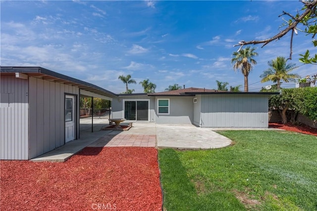 back of house with a lawn and a patio