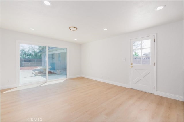 empty room with light wood-type flooring, recessed lighting, baseboards, and a wealth of natural light