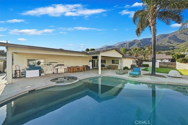 9179 Hidden Farm Rd, Rancho Cucamonga, CA 91737 - view of pool with fence, an outdoor kitchen, a patio area, a mountain view, and a pool with connected hot tub