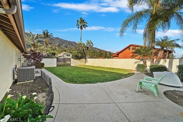 9179 Hidden Farm Rd, Rancho Cucamonga, CA 91737 - view of yard featuring a fenced backyard, central AC unit, a mountain view, and a patio area