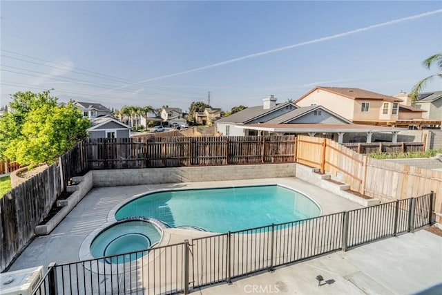 view of swimming pool featuring a patio, a pool with connected hot tub, a residential view, and a fenced backyard