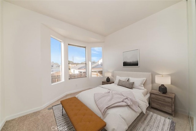bedroom featuring baseboards and light carpet