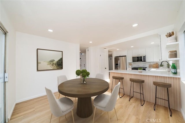 dining area featuring recessed lighting, baseboards, and light wood-style floors