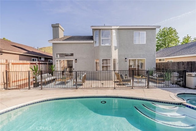 view of pool featuring a fenced backyard, a patio area, and a pool with connected hot tub