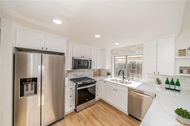 kitchen featuring white cabinetry, open shelves, appliances with stainless steel finishes, and a sink