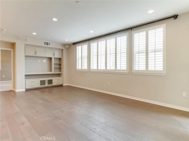 unfurnished living room with recessed lighting, baseboards, visible vents, and light wood-style floors