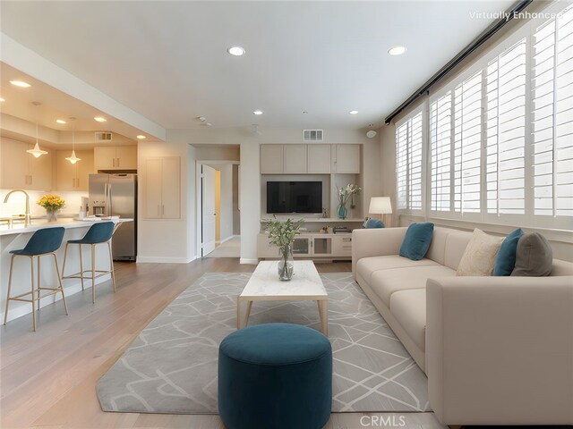 living area featuring recessed lighting, baseboards, visible vents, and light wood-style flooring