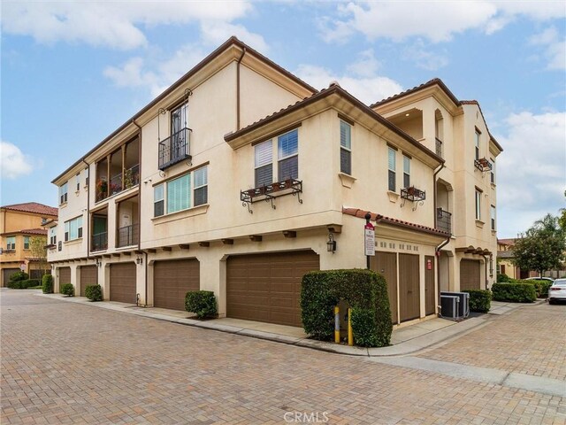 418 Maravilla Ln, Brea, CA 92823 - view of building exterior with central AC unit, a garage, and driveway